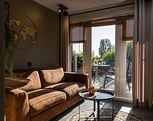 Gezellige woonkamer met toegang tot terras in Vakantiehuisje in Middelburg, Walcheren, Zeeland.