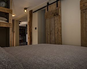 Sfeervolle slaapkamer met houten accenten in Vakantiehuisje in Middelburg, Walcheren, Zeeland.