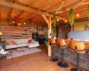 Stijlvolle bar en zithoek in Vakantiehuis in Middelburg, Walcheren, Zeeland met houten elementen en groene accenten.