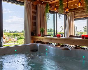 Luxe jacuzzi in Vakantiehuis in Middelburg, Walcheren, Zeeland met uitzicht op de groene omgeving.