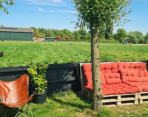 Buitenruimte met comfortabele zitplek in Vakantiehuis in Middelburg, Walcheren, Zeeland met uitzicht op weiland.