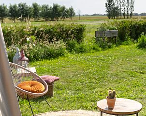 Rustiek terras bij Vakantiehuis in Middelburg, Walcheren, Zeeland met uitzicht op het groene landschap.