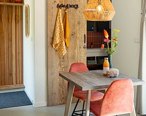 Gezellige eethoek in Vakantiehuis in Biggekerke, Walcheren, Zeeland, met houten tafel en kleurrijke accenten voor een sfeervol verblijf.