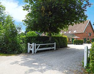 Ingang van VZ136 Studio Grijpskerke, omringd door groene natuur.