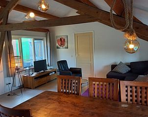 Woonkamer met houten balken in Huisje in Grijpskerke, vakantiewoning in Zeeland.