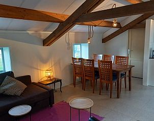 Eetruimte met houten tafel in Huisje in Grijpskerke, vakantiehuis in Walcheren.