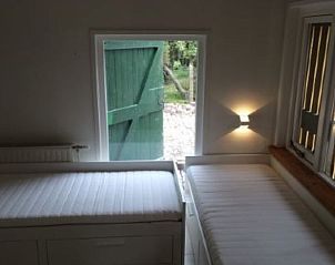 Tweepersoonskamer met uitzicht in Huisje in Grijpskerke, vakantiewoning in Zeeland.