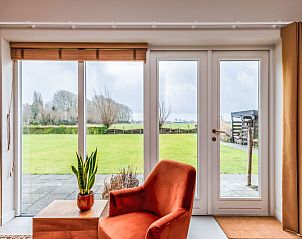 Gezellige binnenruimte van Vakantiehuis De kleine Pionier in Grijpskerke met uitzicht op de tuin, Walcheren, Zeeland.