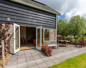 Terras van Vakantiehuis De kleine Pionier in Grijpskerke, Walcheren, Zeeland met zitgelegenheid en toegang tot de tuin.