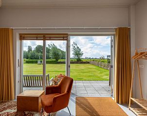 Lichte woonkamer in Vakantiehuis De kleine Pionier, Grijpskerke, Walcheren, Zeeland met uitzicht op de tuin.