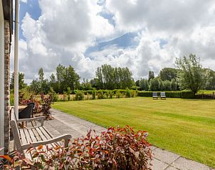Zonnig terras van Vakantiehuis De kleine Pionier in Grijpskerke, Walcheren, Zeeland met groene tuin.