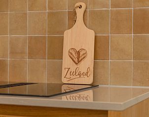 Detail van keuken in Vakantiehuis De kleine Pionier, Grijpskerke, Walcheren, Zeeland met snijplank en tegels.