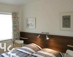 Lichte woonkamer van vakantiehuis ZE159 in Groot Valkenisse, Walcheren, met grote ramen en planten.