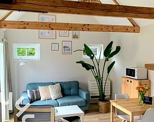 Gezellige woonkamer in vakantiehuis ZE1556 in Gapinge, Walcheren met houten balken.