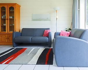 Comfortabele zithoek in VZ641 Vakantiehuis Koudekerke-Dishoek, Walcheren, met kleurrijk vloerkleed.