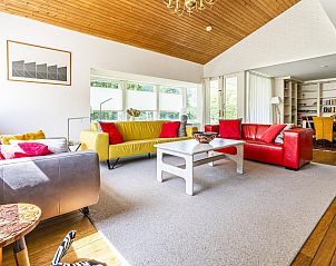 Lichte en ruime woonkamer in VZ937 Vakantiehuis, Koudekerke-Dishoek, Walcheren, met kleurrijke banken en houten plafond.