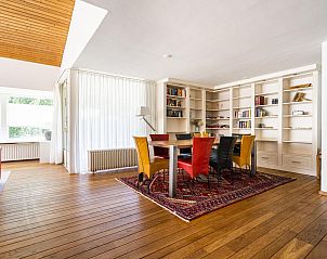 Eetkamer in VZ937 Vakantiehuis, Koudekerke-Dishoek, Walcheren, met houten vloeren en kleurrijke stoelen voor gezellige diners.