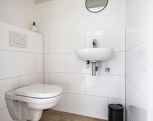 Compacte en moderne toilet in VZ937 Vakantiehuis, Koudekerke-Dishoek, Walcheren, met witte tegels en minimalistisch design.
