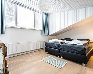 Slaapkamer met tweepersoonsbed in VZ937 Vakantiehuis, Koudekerke-Dishoek, Walcheren, met houten vloeren en veel licht.