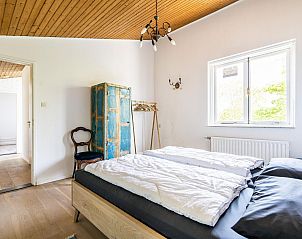 Slaapkamer in VZ937 Vakantiehuis, Koudekerke-Dishoek, Walcheren, met houten plafond en antieke kast.