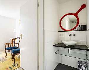 Stijlvolle wastafel in VZ937 Vakantiehuis, Koudekerke-Dishoek, Walcheren, met opvallende rode spiegel.