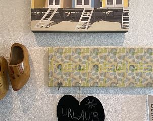 Authentieke decoratie in Casa Mari, chalet in Breskens, Zeeuws-Vlaanderen, met klompen en strandkunst voor een lokale sfeer.