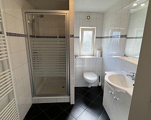 Stijlvolle badkamer in VZ807 Vakantiehuis Breskens met douche en wastafel in Zeeland.