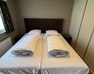 Slaapkamer met televisie in VZ807 Vakantiehuis Breskens, ideaal voor ontspanning in Zeeuws-Vlaanderen.