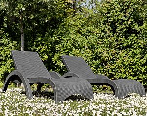 Sonnige Liegen im Garten der Lodge 4B, Breskens, Zeeland, umgeben von blhenden Blumen und Grn.