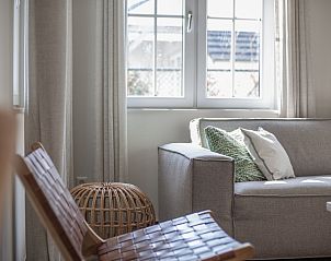 Stylish dining room in Watervilla 8B Luxury, vacation home in Cadzand-bad, Zeeuws-Vlaanderen, with views of nature through large windows.
