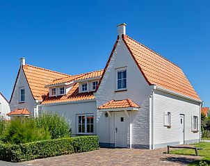 Villa 8G Luxe in Cadzand-bad, Zeeuws-Vlaanderen, a charming vacation home with red roof tiles and green surroundings for a relaxing stay.