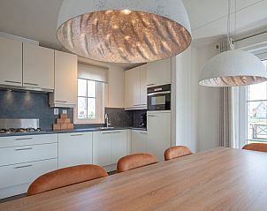 Modern kitchen in Villa 8G Luxe, a stylish vacation home in Cadzand-bad, Zeeuws-Vlaanderen, with spacious dining area and large windows.