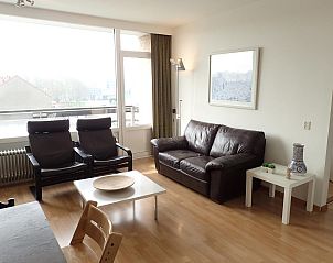 Cozy living room of VZ922 Holiday apartment in Cadzand, with leather sofa and large windows for lots of light.