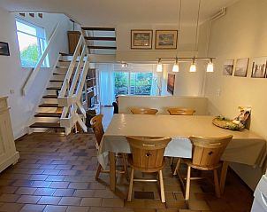Dining area in VZ924 Holiday home in Cadzand with wooden chairs and spacious table, Zeeland.