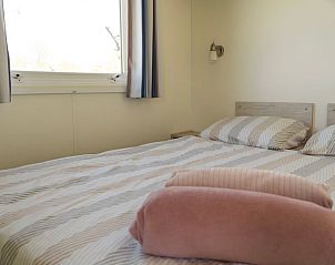 Gemtliches Schlafzimmer im Ferienhaus in Hengstdijk, Zeeuws-Vlaanderen, mit bequemem Bett und erholsamer Aussicht auf die Natur.