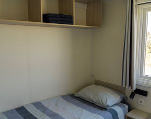 Gemtliches Schlafzimmer im Ferienhaus in Hengstdijk, Zeeuws-Vlaanderen, mit bequemen Betten und Blick auf die friedliche Landschaft Zeelands.