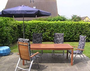 Ruim terras bij Vermare in Wemeldinge, Zuid-Beveland, met comfortabele tuinstoelen en parasol.