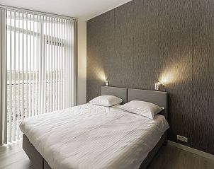 Slaapkamer met tweepersoonsbed in Vakantiehuis Ruisweg 71, vakantiehuis in Wemeldinge, Zeeland, serene sfeer.