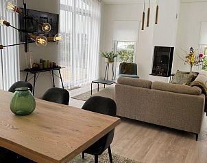 Eetkamer met houten tafel in Vakantiehuis Waterresort Oosterschelde huisnr. 68, Zeeland, perfect voor familiediners.