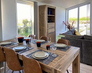 Eetruimte in Vakantiehuis Waterresort Oosterschelde huisnr. 83 in Wemeldinge, Zuid-Beveland, met grote eettafel en veel lichtinval.