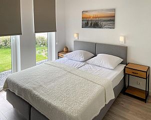Lichte slaapkamer in Vakantiehuis Waterresort Oosterschelde huisnr. 83 in Wemeldinge, met uitzicht op de tuin.