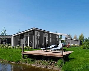 Vakantiehuis Waterresort Oosterschelde in Wemeldinge met zonnig terras en ligstoelen, ideaal voor ontspanning in Zeeland.