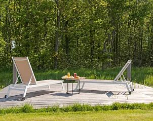 Privterras met ligstoelen bij Vakantiehuis Waterresort Oosterschelde, omgeven door natuur in Wemeldinge, Zuid-Beveland.