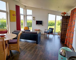 Gezellige zithoek in Vakantiehuis Ruisweg 51, Wemeldinge, met uitzicht op het groene landschap.