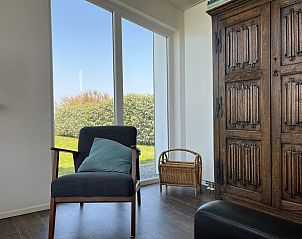 Knusse leeshoek in Vakantiehuis Ruisweg 51, Wemeldinge, met uitzicht op de tuin.