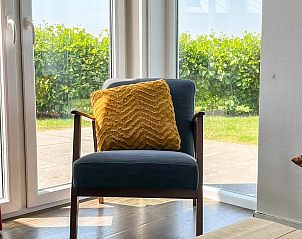 Comfortabele stoel in de woonkamer van Vakantiehuis Waterresort Oosterschelde huisnr. 51 in Wemeldinge, met uitzicht op tuin.