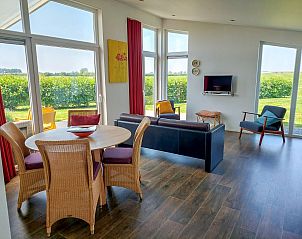 Eetkamer en woonkamer in Vakantiehuis Waterresort Oosterschelde huisnr. 51, met veel licht en uitzicht op de natuur in Zeeland.