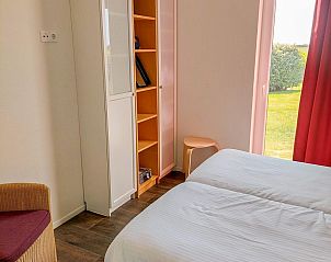 Slaapkamer in Vakantiehuis Waterresort Oosterschelde huisnr. 51 in Wemeldinge, met moderne inrichting en tuinzicht.