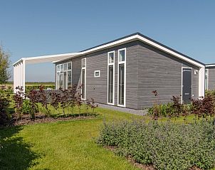 Zijaanzicht van Vakantiehuis Waterresort Oosterschelde huisnr. 39 in Wemeldinge, omgeven door weelderige tuin.