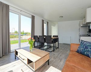 Stijlvolle woonkamer in Vakantiehuis Hart van Zeeland met uitzicht op de tuin in Heinkenszand.